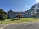 Side view of a house with a metal roof and landscaping at 409 W Main St, Spring Hope, NC 27882