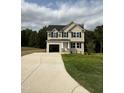 Two-story house with beige siding, black windows, and a concrete driveway at 153 Wynd Crest Way, Benson, NC 27504