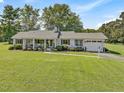 Ranch-style home with white brick exterior, front porch, and attached garage at 4147 Siler City Snow Camp Rd, Siler City, NC 27344