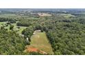 Aerial view of a house on a large lot with surrounding trees and farmland at 8463 Running Creek Rd, Gibsonville, NC 27249