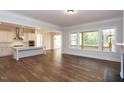 Open kitchen with white cabinets, island, and hardwood floors at 143 Traceway N, Sanford, NC 27332
