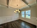Bright dining room features hardwood floors, wainscoting, and a beautiful chandelier at 824 Putney Hill Rd, Zebulon, NC 27597