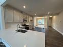 Modern kitchen with white quartz countertops and stainless steel sink at 824 Putney Hill Rd, Zebulon, NC 27597