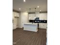 Modern kitchen featuring white cabinets, an island, and dark flooring at 605 Hyperion Aly, Wake Forest, NC 27587