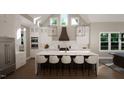 Modern kitchen with white cabinets, large island, and high ceilings at 9417 Rawson Ave, Raleigh, NC 27613