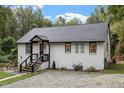 Renovated white brick home with a gravel driveway and mature trees at 306 E Knox St, Durham, NC 27701