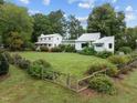 Two-house property with large yard, showcasing a white farmhouse and modern addition at 1021 Dimmocks Mill Rd, Hillsborough, NC 27278