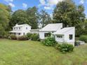 Two-house property with large yard, showcasing a white farmhouse and modern addition at 1021 Dimmocks Mill Rd, Hillsborough, NC 27278