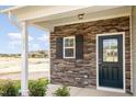 Dark green front door with stone surround and white framed window at 275 Trescott St, Smithfield, NC 27577