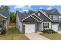 Gray-toned two-story townhome with a white garage door and landscaping at 108 Cullen Ct, Clayton, NC 27520