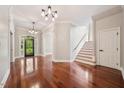 Grand foyer with hardwood floors, elegant chandelier, and staircase at 6300 Swallow Cove Ln, Raleigh, NC 27614