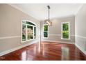 Bright dining room with hardwood floors, large windows, and elegant light fixture at 6300 Swallow Cove Ln, Raleigh, NC 27614