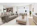 Open concept living room with neutral colored couch and a large window at 2412 Adrift Road, Fuquay Varina, NC 27526