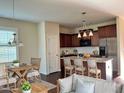 Eat-in kitchen with an island, stylish light fixtures, and a view into the living room at 24 Manito Pl, Clayton, NC 27520