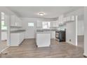Remodeled kitchen with white cabinets, granite countertops and island at 2171 Bud Lipscomb Rd, Willow Springs, NC 27592