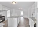 Bright kitchen with white cabinets, granite island, and wood flooring at 2171 Bud Lipscomb Rd, Willow Springs, NC 27592
