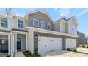 Townhouse exterior with gray siding, stone accents, and a two-car garage at 746 Apple Churn Dr, Fuquay Varina, NC 27526