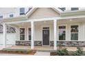 Covered front porch with stone base, white columns, and dark gray door at 260 Umstead St, Sanford, NC 27330