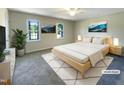 Virtually staged bedroom with a large bed, two windows, and neutral wall colors at 27 Pine Croft Rd, Angier, NC 27501