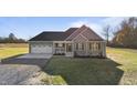 Inviting green two-story home on a sunny day with a two-car garage and spacious front lawn at 7814 Nc 27, Coats, NC 27521