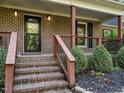 Front entry with brick steps, red railings, and landscaping at 363 Dublin Dr, Sanford, NC 27330