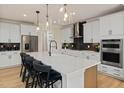 Modern kitchen with white cabinets, quartz countertops, and stainless steel appliances at 116 E Star Foal Ln, Wendell, NC 27591