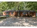 Brick ranch house with a wooden front porch and a gravel driveway at 118 W Silver Belle Dr, Zebulon, NC 27597