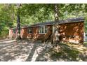 Brick ranch house with a wooden front porch and a gravel driveway at 118 W Silver Belle Dr, Zebulon, NC 27597