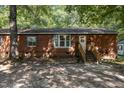 Brick ranch house with a wooden front porch and a gravel driveway at 118 W Silver Belle Dr, Zebulon, NC 27597