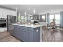 Open concept kitchen with island, gray cabinets, and stainless steel appliances at 5013 Trotter Dr, Raleigh, NC 27603
