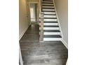 Modern staircase with dark wood accents and white risers at 1920 Fishamble St, Fuquay Varina, NC 27526