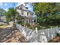 Charming two-story home with a white picket fence and brick driveway at 1000 Lamond Ave, Durham, NC 27701