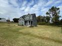 Two story home with gray siding, landscaping, and stone accents at 230 Grading Stick Ct, Angier, NC 27501