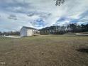Rear view of a two-story house with a deck overlooking a large backyard at 23 Quail Point Cr, Clayton, NC 27520