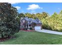 Two story home with brick and gray siding, two car garage, and landscaping at 319 River Knoll Dr, Clayton, NC 27527