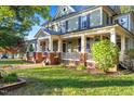 Large two-story house with a wrap-around porch and brick accents at 26 Oak St, Roxboro, NC 27573