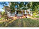 Large two-story house with a wrap-around porch and brick accents at 26 Oak St, Roxboro, NC 27573