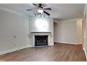 Living room with fireplace, wood-look floors and ceiling fan at 1414 Arborgate Cir, Chapel Hill, NC 27514