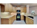 Kitchen with light wood cabinets, black appliances, and tile floors at 1414 Arborgate Cir, Chapel Hill, NC 27514
