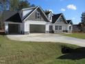 Two story home with gray and white siding, stone accents, and a large garage at 265 Coats Ridge Dr, Benson, NC 27504