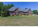 Brick home with a large lawn and mature trees at 512 W Franklin St, Zebulon, NC 27597