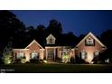 Brick home with a large lawn and mature trees, nighttime view at 512 W Franklin St, Zebulon, NC 27597