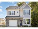 Two-story house with gray and beige siding, stone accents, and a two-car garage at 5400 Razan St, Raleigh, NC 27616