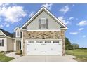 Two-car garage with stone and gray accents at 45 S Harper Faith Way, Benson, NC 27504