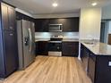 Modern kitchen with dark cabinetry and granite countertops at 103 Hampshire Pl, Kenly, NC 27542