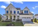 Two-story farmhouse with white siding, gray roof and a two-car garage at 616 Silver Comet Dr, Knightdale, NC 27545