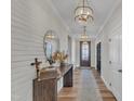 Bright entryway with hardwood floors, a statement light fixture, and white brick feature wall at 616 Silver Comet Dr, Knightdale, NC 27545