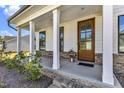 Inviting front porch with wooden columns and a glass front door at 616 Silver Comet Dr, Knightdale, NC 27545