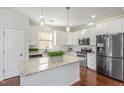 Kitchen with white cabinets, granite island and stainless steel appliances at 517 Birchrun Dr, Durham, NC 27712