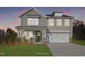 Two-story home with a neutral color scheme, two-car garage, and landscaping at dusk at 23 Eagle Crest Ct # Holly English Country, Lillington, NC 27546